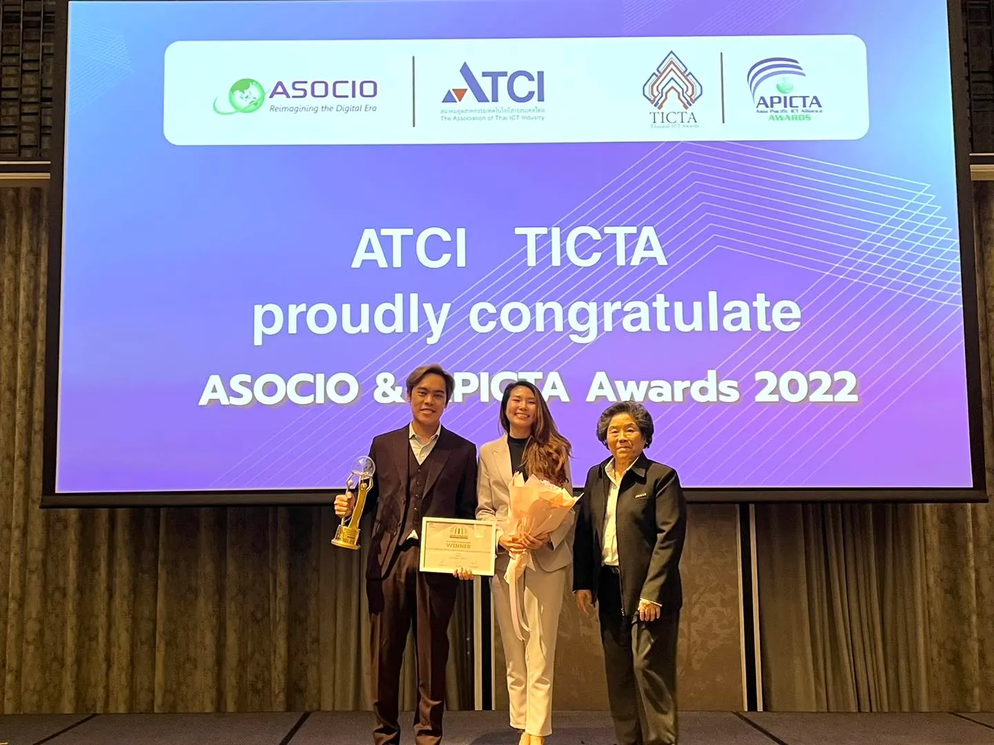 ผู้แทน HealthTAG ถือถ้วยและประกาศนียบัตรในงาน APICTA Awards 2022